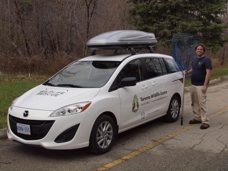 Andrew stands beside new rescue car.